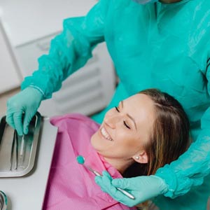 A woman smiling as a dentist examines her teeth